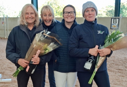 Four smiling members of Helen Atkin Group RDA holding bouquets of flowers in the covered arena in Buxton